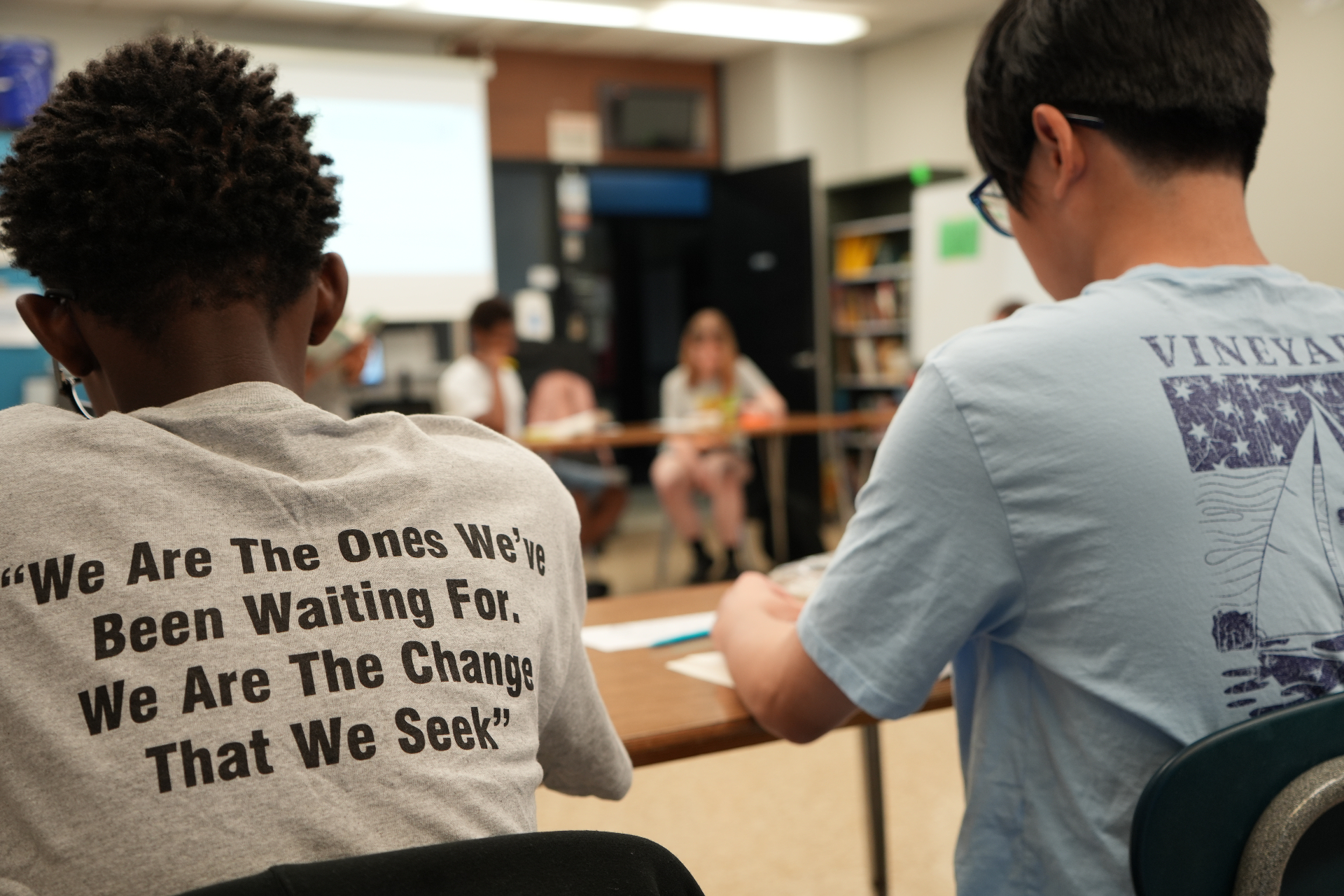 Elevation Project students in a classroom discussion wearing a shirt reading 'We are the ones we've been waiting for. We are the change that we seek.'